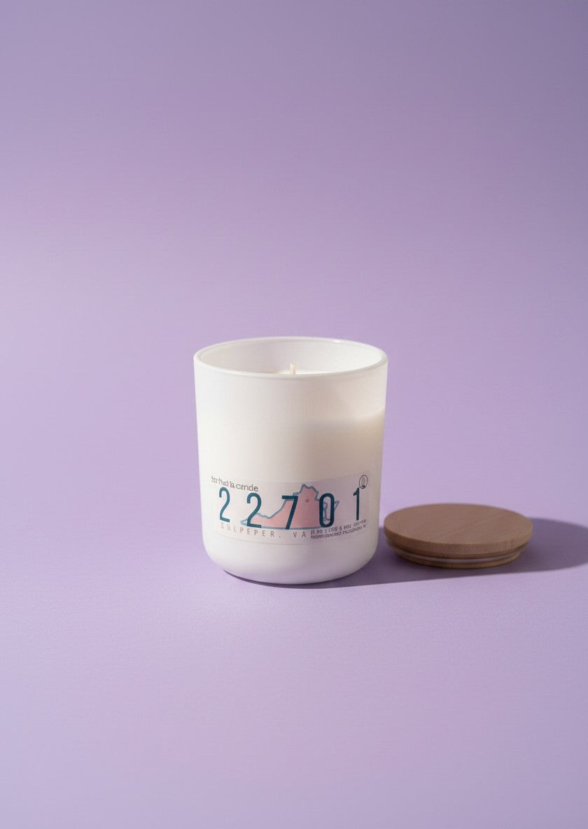 A white glass jar candle with a printed label reading '22701'.